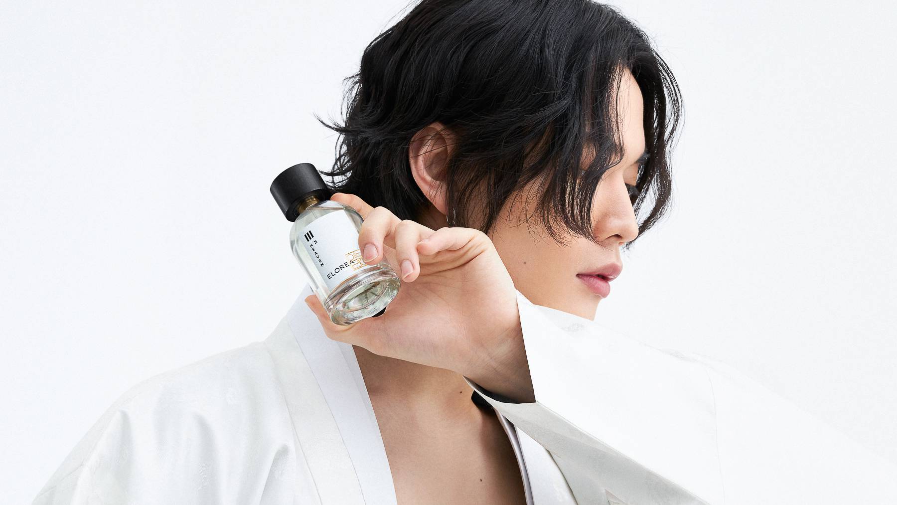 Model in traditional Korean attire holding Elorea perfume.