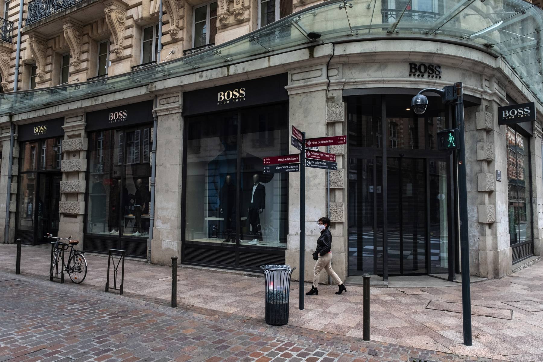 A pedestrian passes a closed Hugo Boss store during lockdown in Toulouse, France