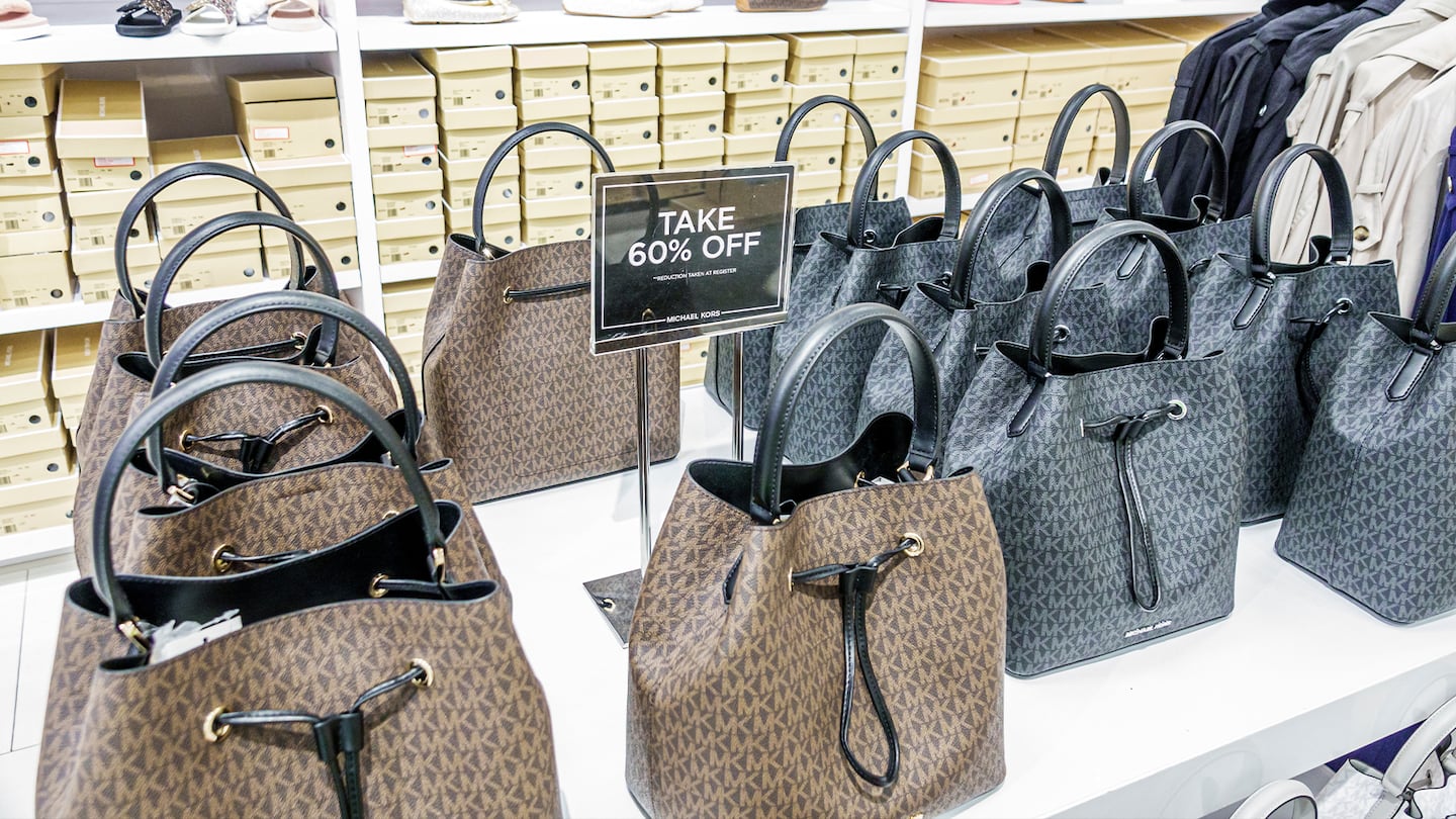 The economic climate has the potential to both benefit and hurt Michael Kors, Ralph Lauren and other brands catering to aspirational consumers.
