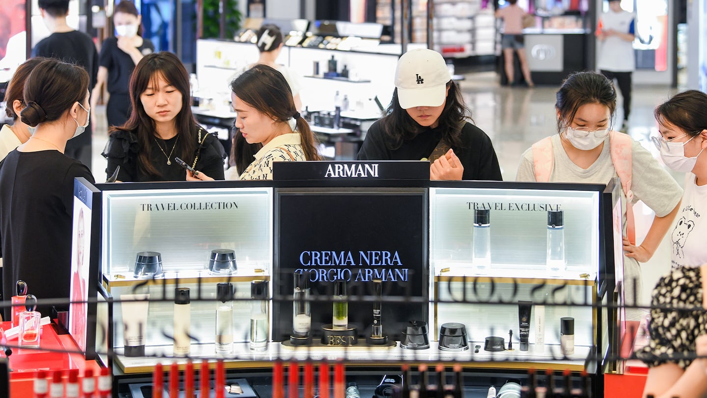 Tourists purchase cosmetic products at CDF Haikou Duty Free Shop during summer vacation.