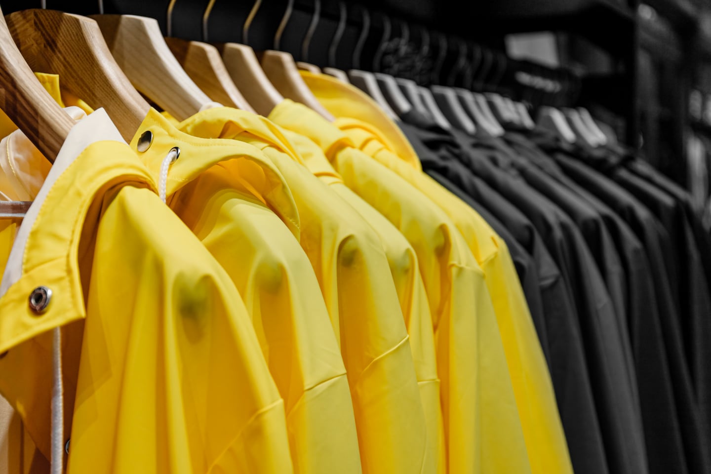Close-up of a clothes rack displaying yellow and black raincoats.