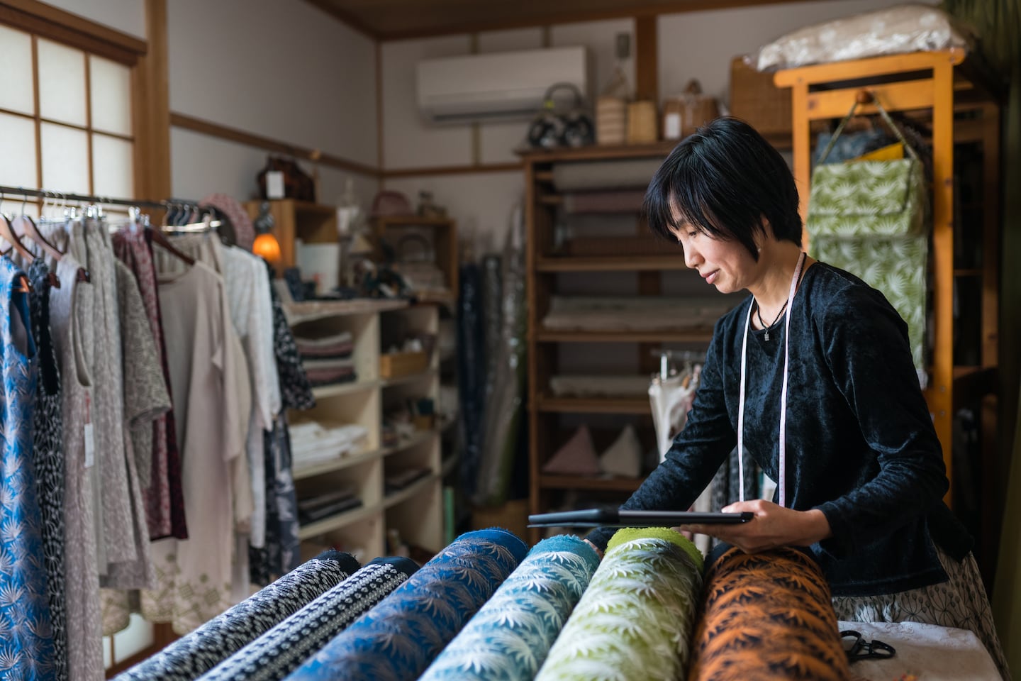 A Japanese shopkeeper inspects locally-made textiles. Getty Images.