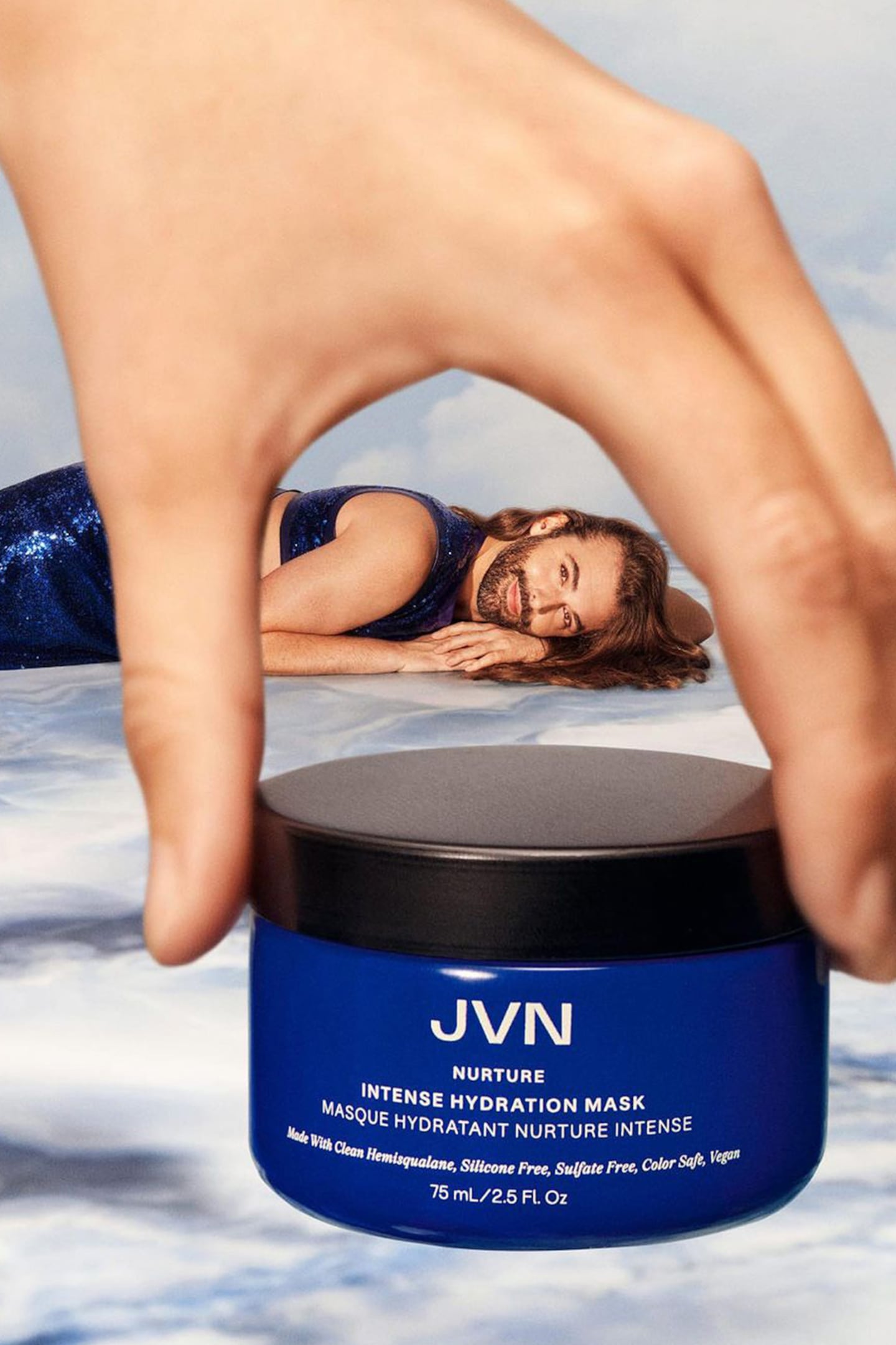 An image of Johnathan Van Ness playfully posing with a hair product.