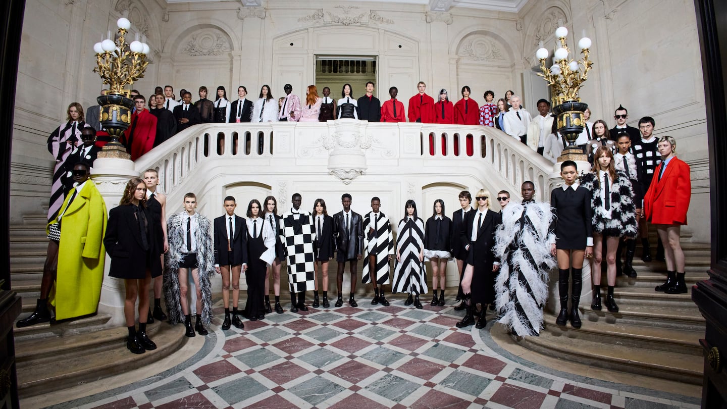 Models wearing the Valentino collection stand arranged on a staircase and balcony.