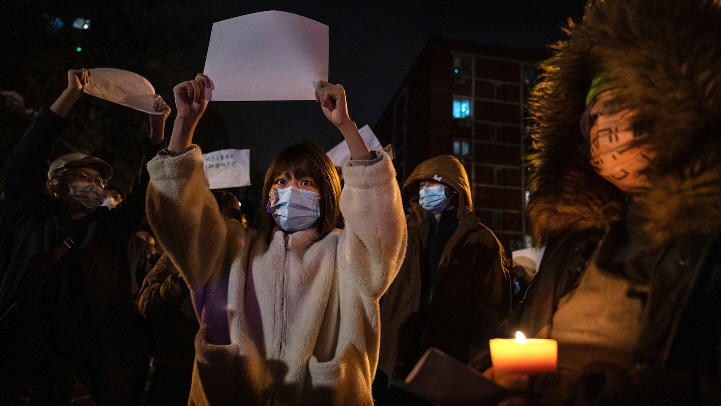 Protesters in Beijing hold up a white piece of paper against censorship as they march during a protest against China's strict zero-Covid measures.