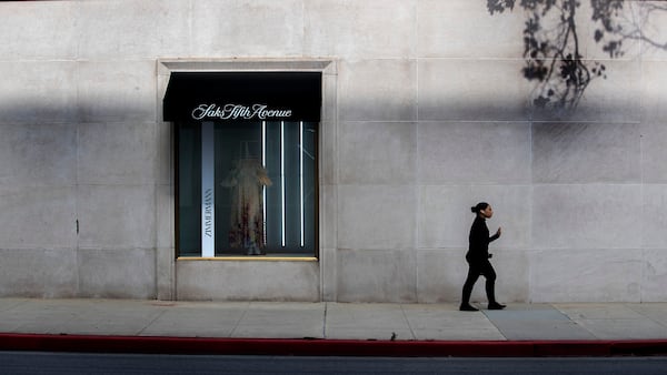 Woman walking past Saks Fifth Avenue building