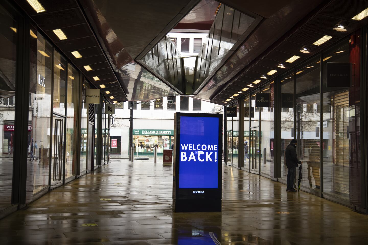 An electronic sign welcomes back shoppers in an empty mall in London on February 15. Jason Alden/Bloomberg via Getty Images.