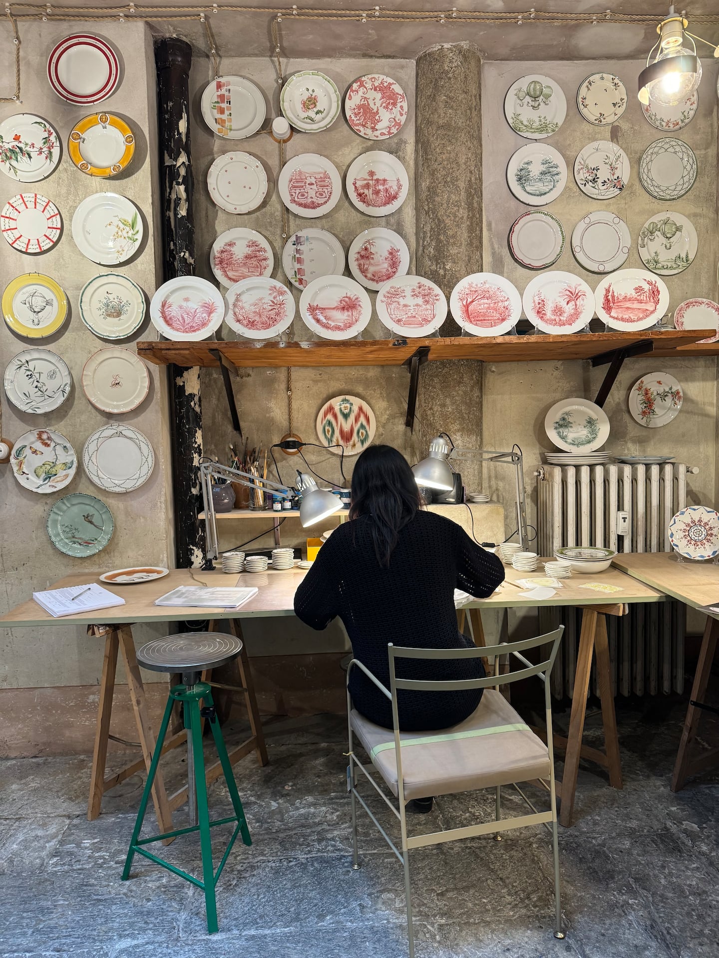 Artisan paints porcelain plates at Laboratorio Paravicini during MIlan Design Week.