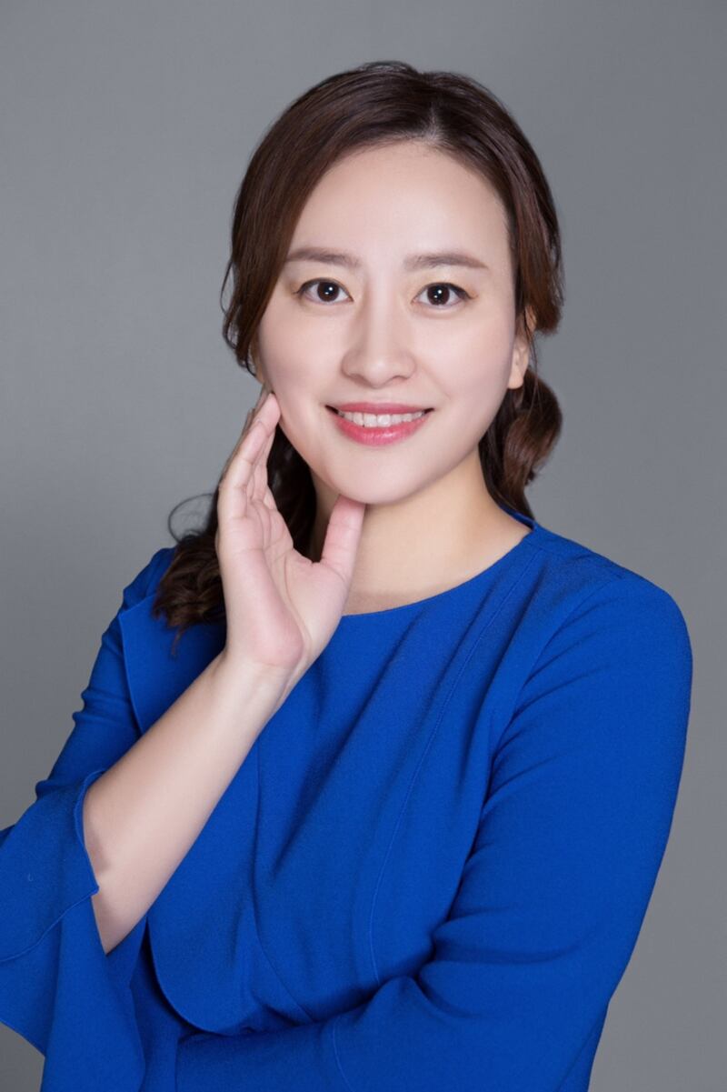 Lynn Dong wearing a blue long sleeved top.