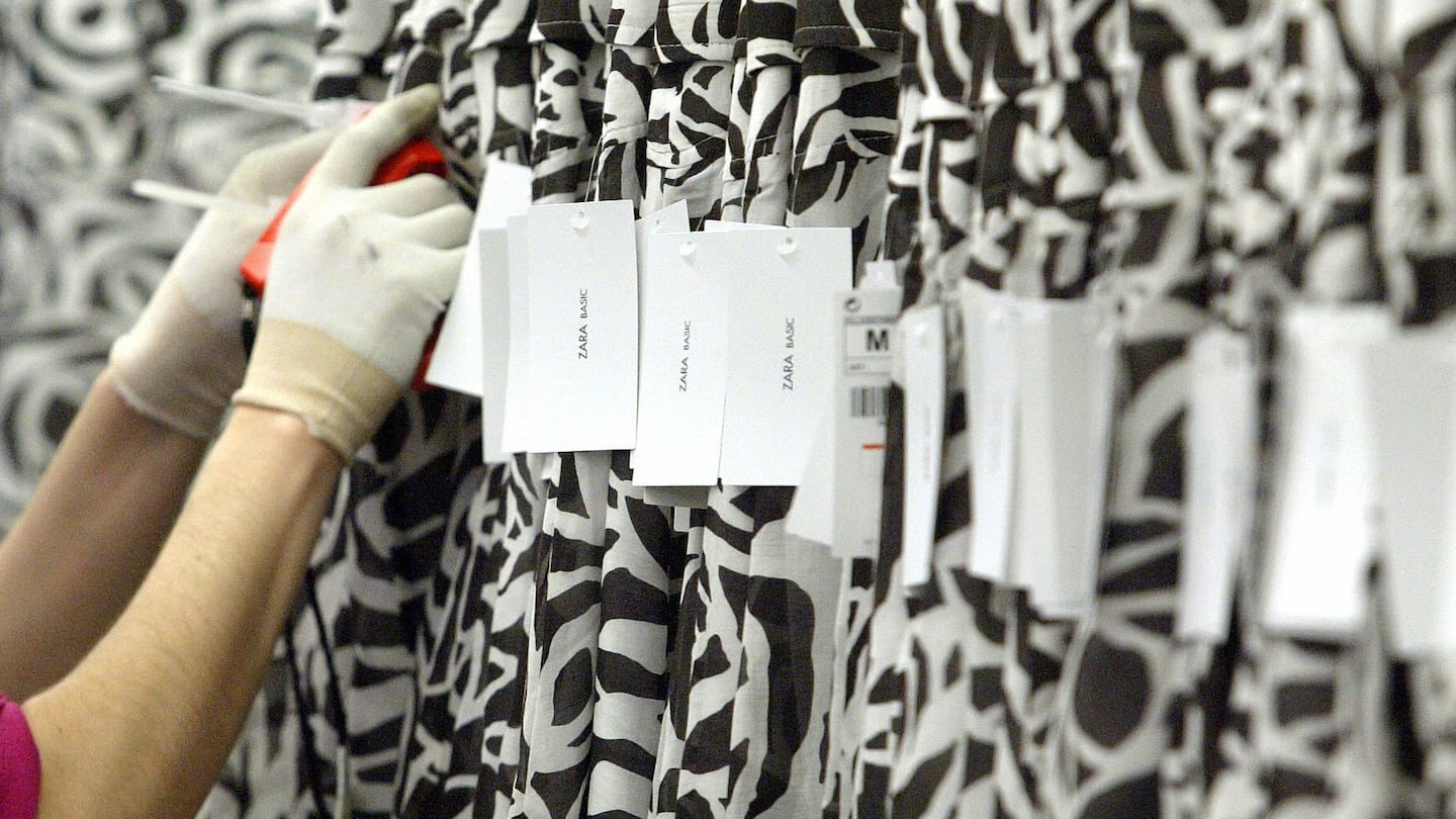 A woman attaches price tickets to 'fast fashion' skirts at a factory.