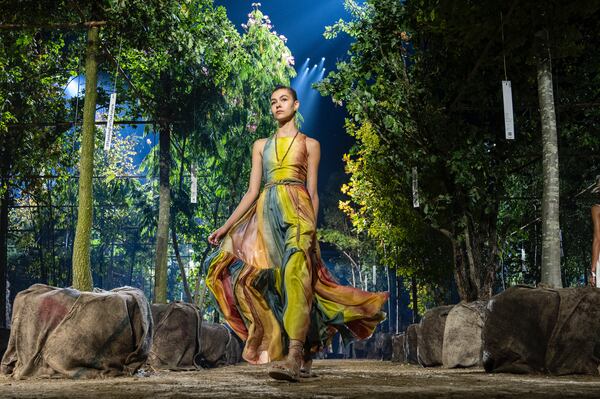 A model walks a forested runway for Dior