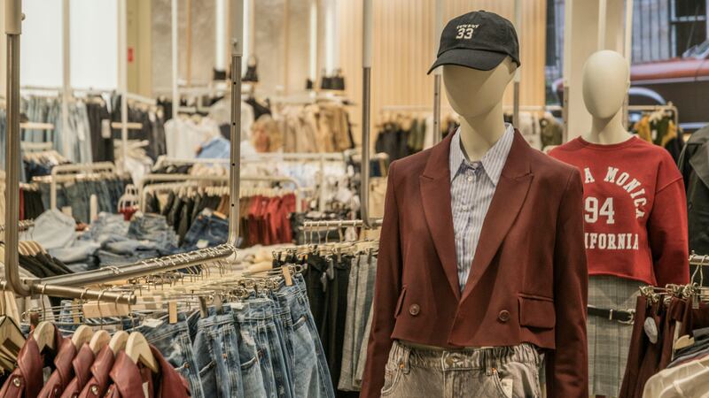 Fashion mannequins in stylish clothing display in a contemporary retail setting.