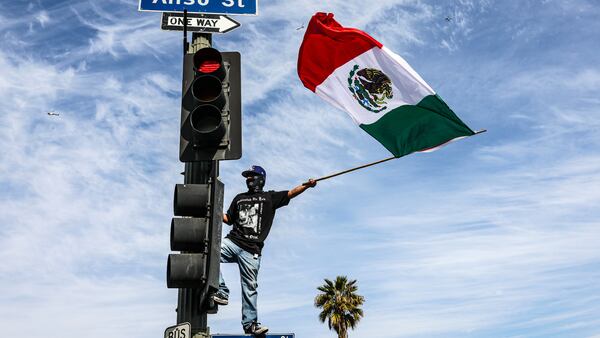 A person waving a Mexican flag during a march organized in Los Angeles in February to protest the Trump administration’s current immigration policies. The protestor is wearing garments by Born X Raised, a streetwear label founded in 2013 by Alex “2Tone” Erdmann and Chris “Spanto” Printup that’s dedicated to telling stories about the diverse communities behind the culture of Los Angeles.