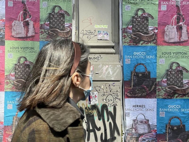 A pedestrian walks past PETA campaign posters in New York on April 20, 2022.