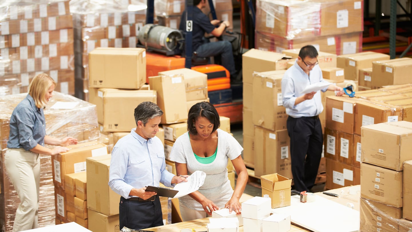 Workers in a warehouse preparing goods for dispatch.