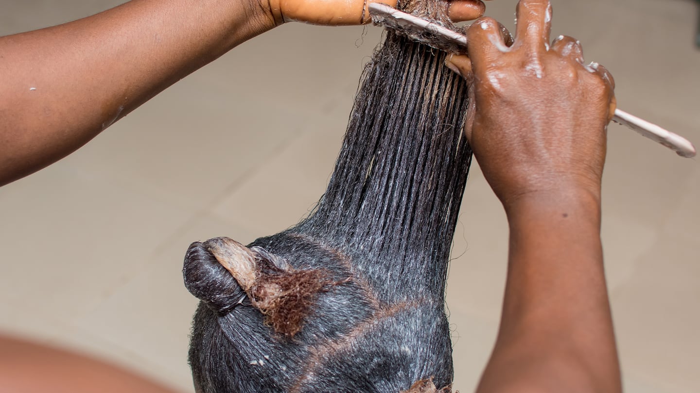 A woman getting her hair chemically straightened