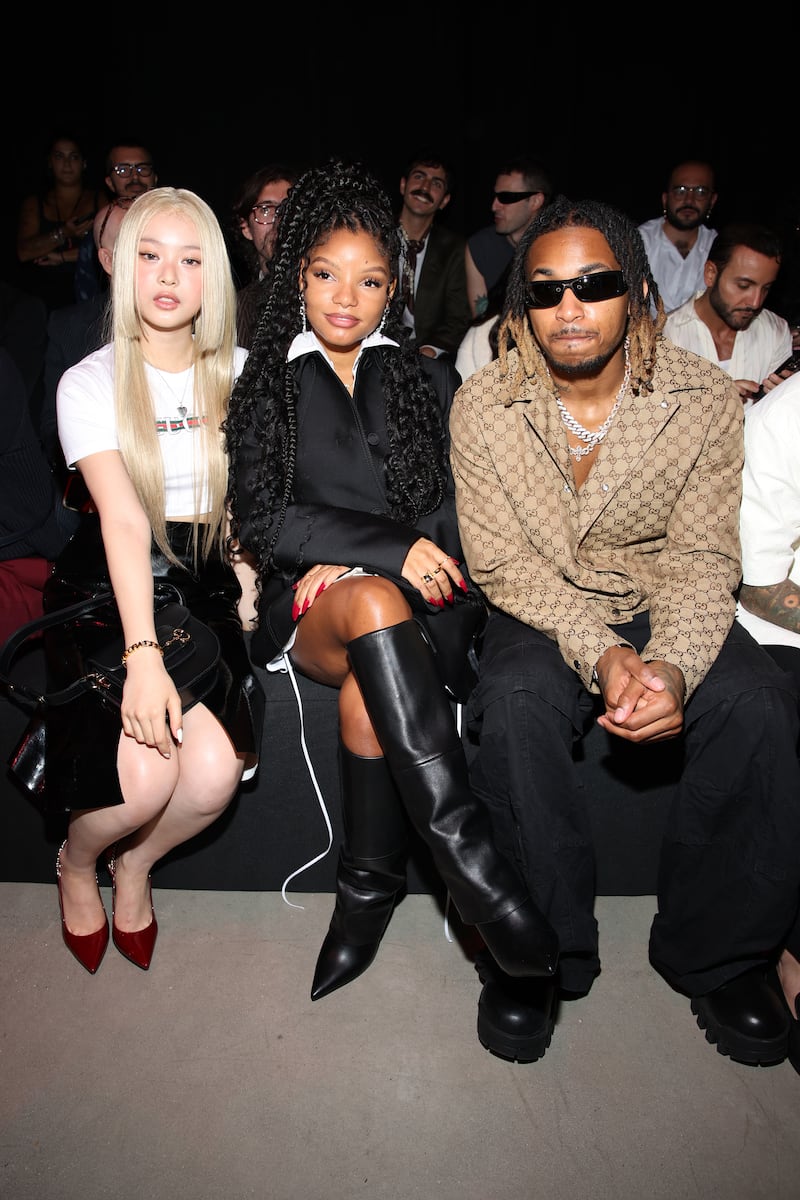 NewJeans member Hanni (L) sits front row next to Halle Bailey (C) and DDG (R) at the S/S 24 Gucci show during Milan Fashion Week in September 2023 in Milan, Italy.