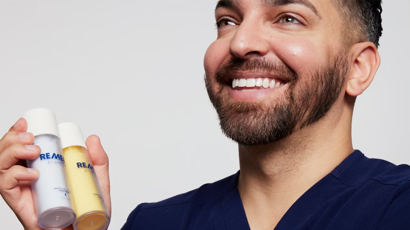 Dr. Muneeb Shah holding his Remedy Skin label skincare products.