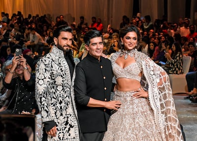 Bollywood actors Ranveer Singh, fashion designer Manish Malhotra and Deepika Padukone wearing looks by the designer at a fashion show for the Mijwan Welfare Society in Mumbai.