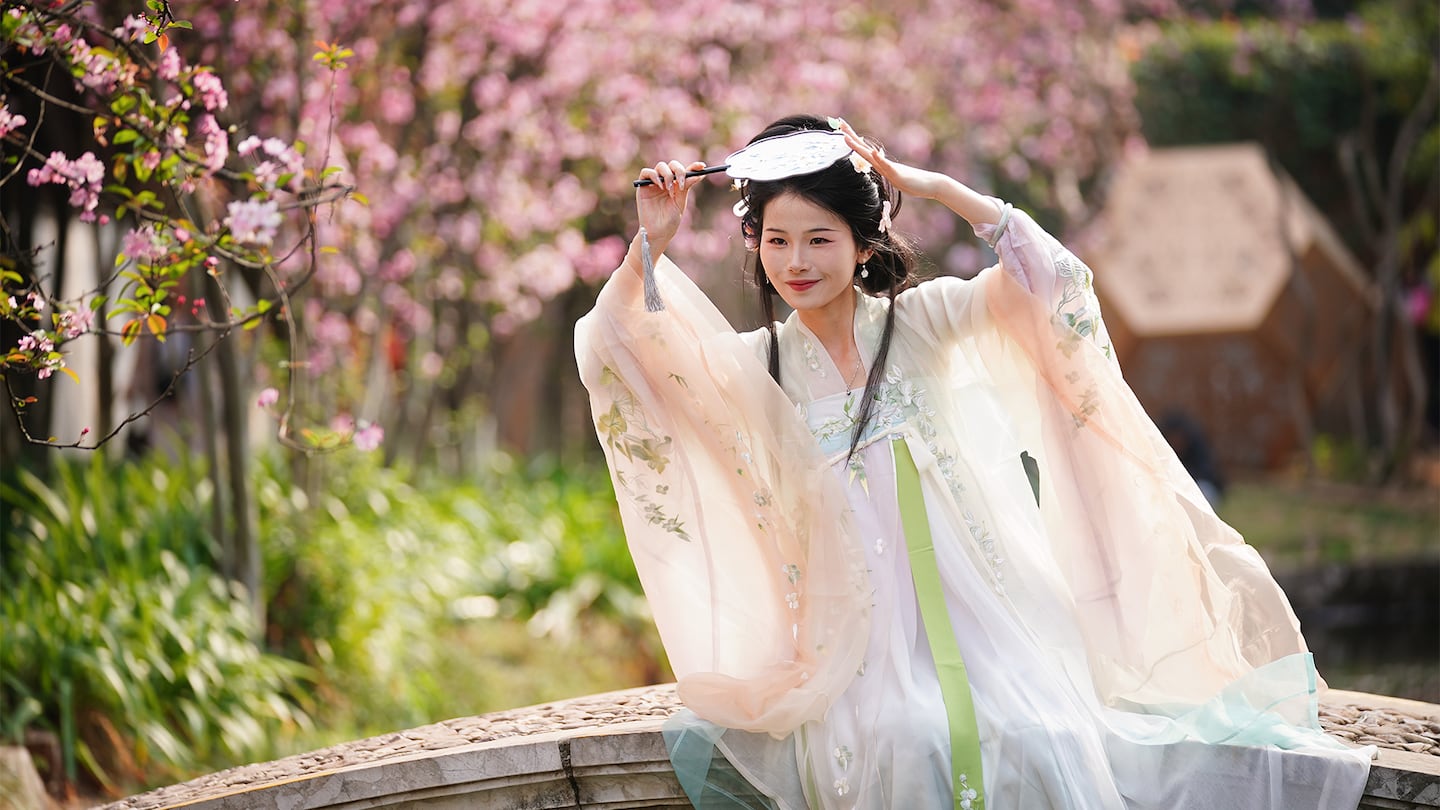 A woman dressed in traditional Hanfu costume poses for a photo at Daguan Park in Kunming, Yunnan Province in southwest China.