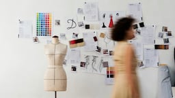 Fashion student with a dress form and designs.