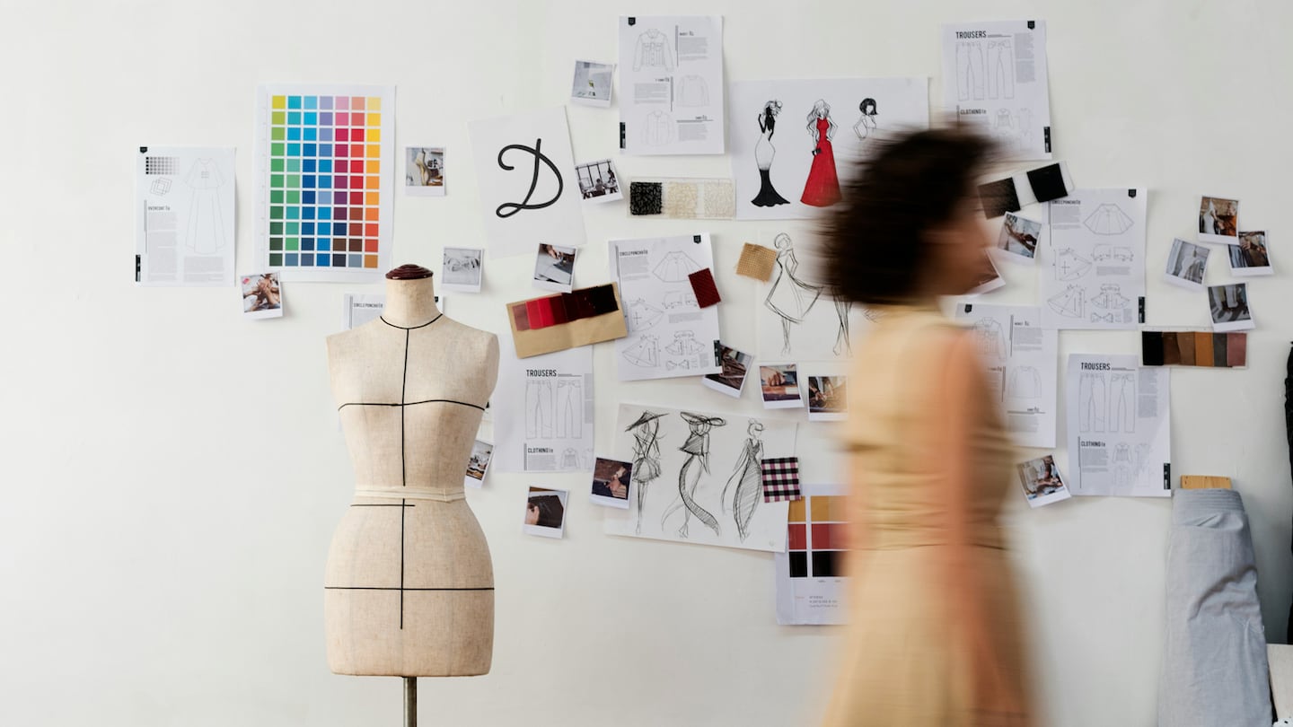 Fashion student with a dress form and designs.