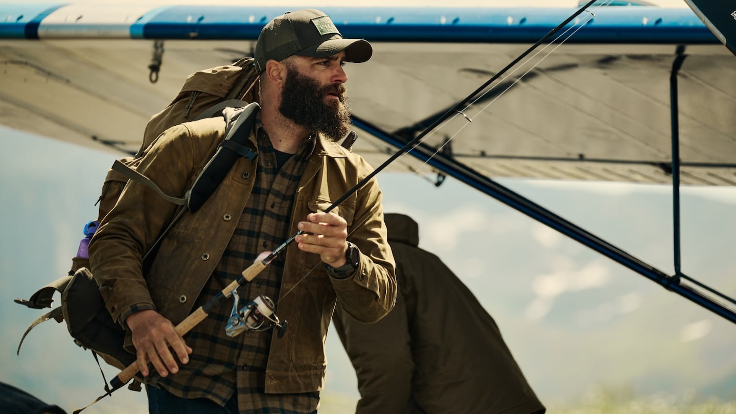 A person holds a rod while posing in a Filson ad