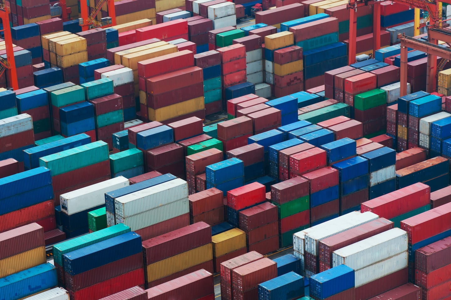 A variety of cargo freight containers stacked up at a sea port.
