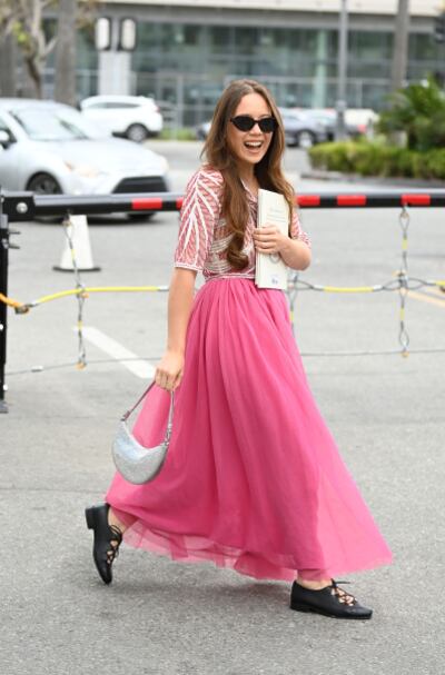 Gen-Z musician Laufey wears the Kate Spade crescent-moon shaped Duo bag.