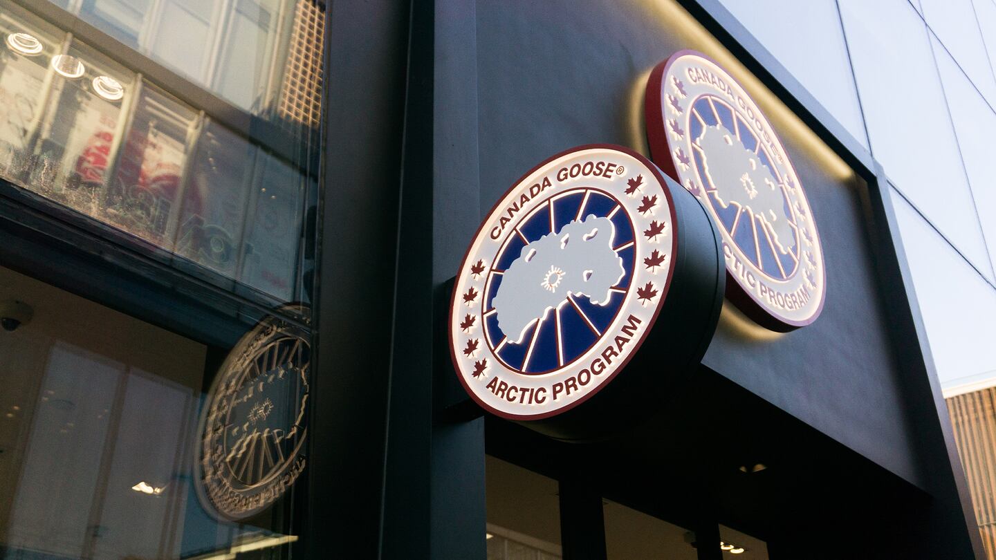 Canada Goose store with two large crest signs at the front of the black store windows.