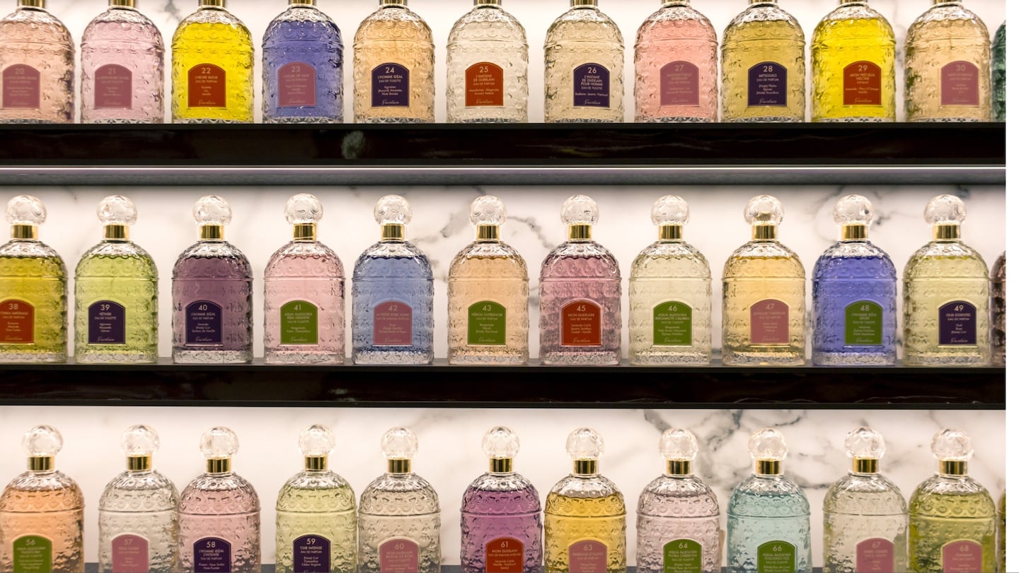 Rows of perfume bottles on store shelves.