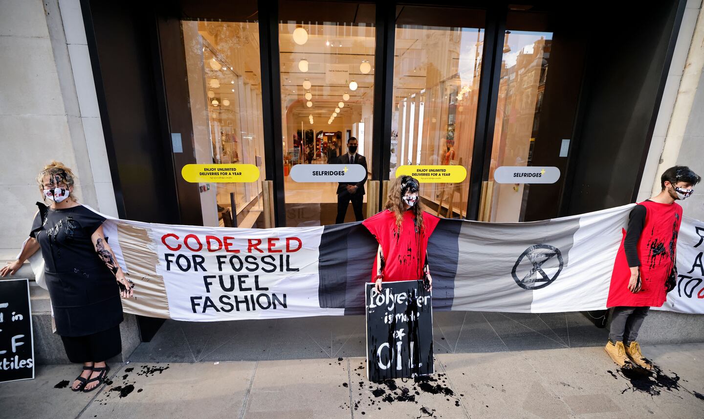 Activists from the Extinction Rebellion demonstrate outside Selfridges store in central London on August 24, 2021 during the group's 'Impossible Rebellion' series of actions.