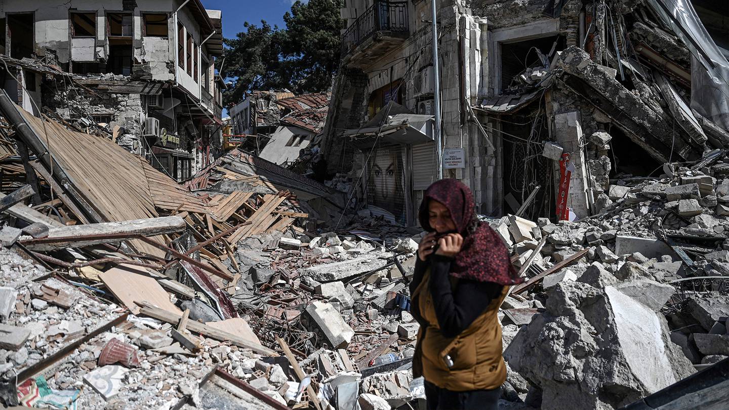 A woman walks in the rubble of a collapsed building after a deadly series of earthquakes in Turkey and Syria last month.