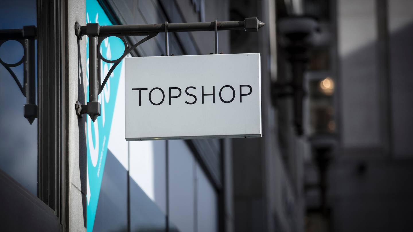 A sign and logo for Topshop store