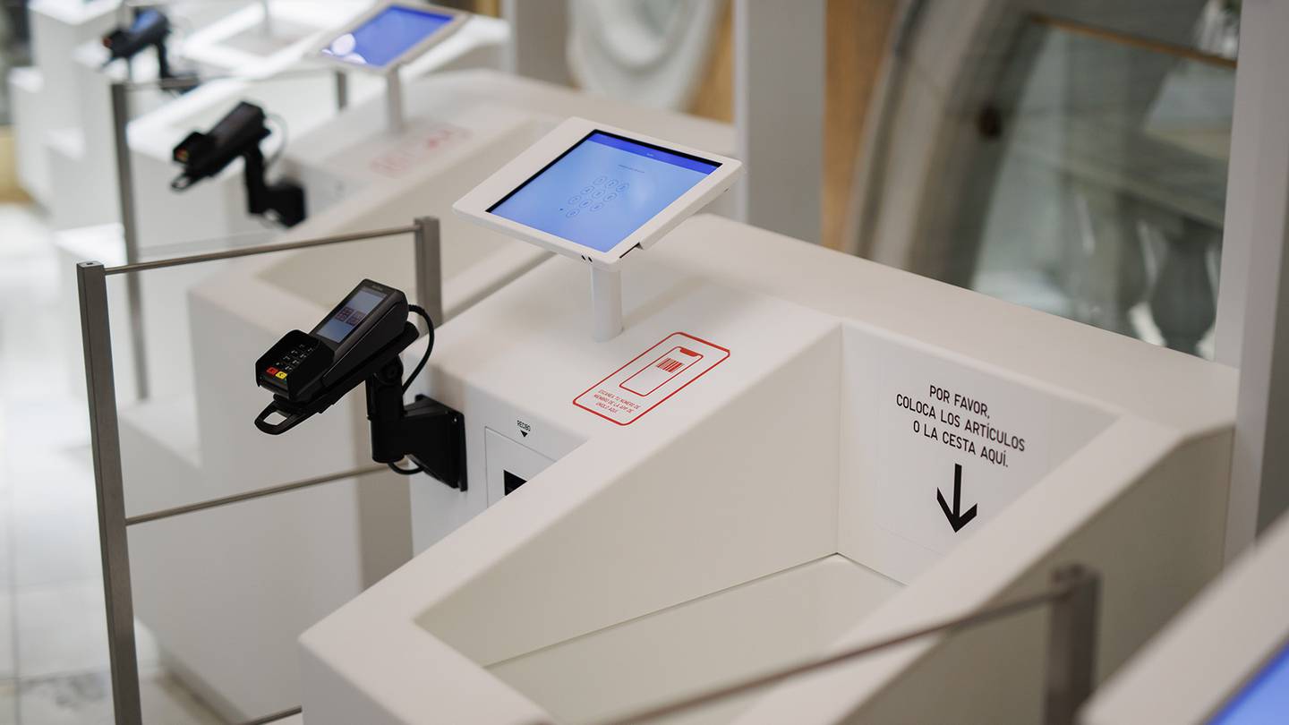 A close up of Uniqlo's self-checkout bin, which has a screen to the left side and a card reader for payment.