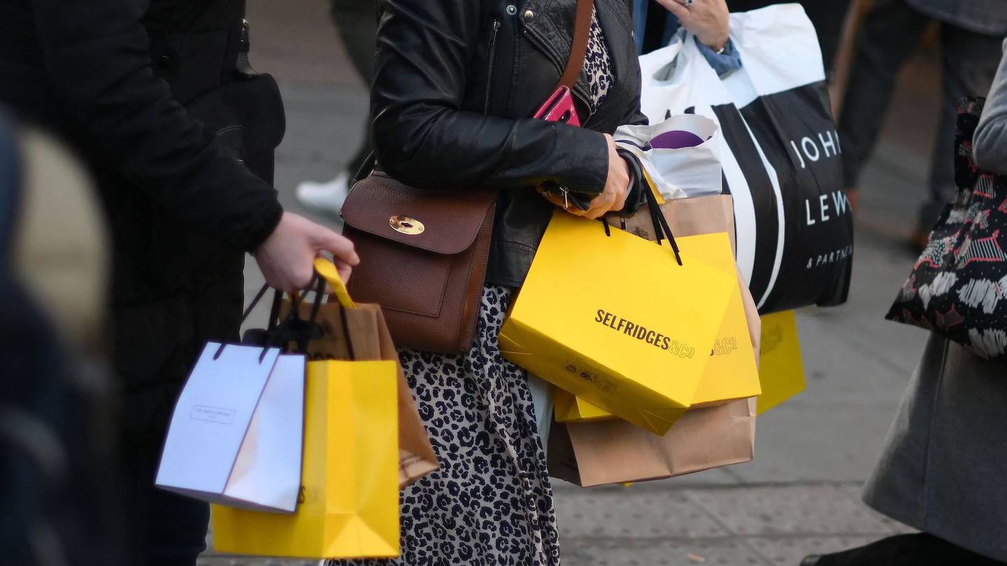 Shoppers carry purchases in Selfridges-branded shopping bags on Black Friday in central London on November 25, 2022.