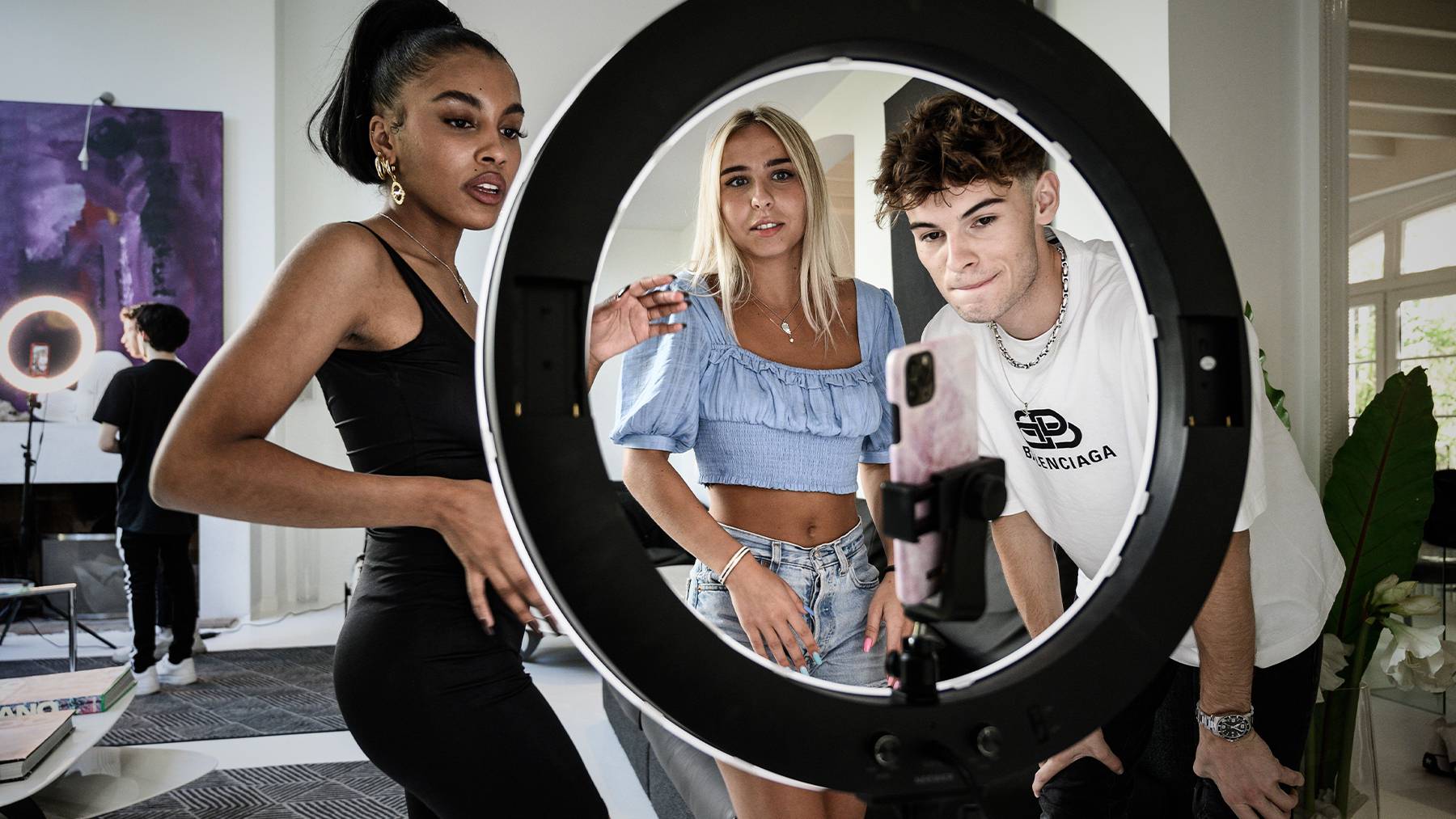 TikTok Influencers pose in front of camera and ring light.
